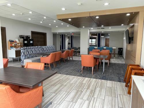 a restaurant with tables and chairs and a bar at Holiday Inn Express Hotel & Suites Tipp City by IHG in Tipp City