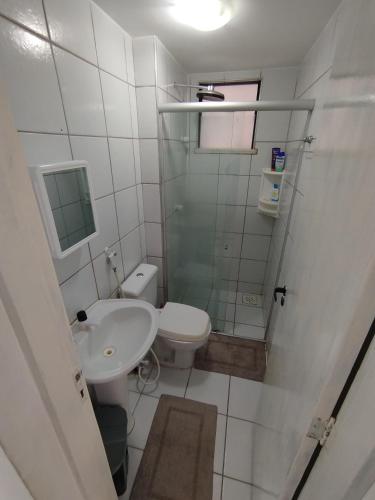 a small bathroom with a toilet and a sink at Cumbuco Geek House in Cumbuco