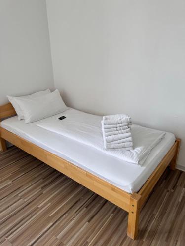 a bed with white sheets and towels on it at private Zimmer im Serviced Apartment - mit wöchentlicher Reinigung in Stuttgart