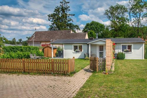 a house with a wooden fence in the yard at Ferienhaus Ankerplatz Bellin in Ueckermünde