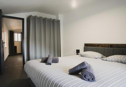 a bedroom with a large bed with towels on it at Le Passage - Centre-ville - WiFi in Issoire