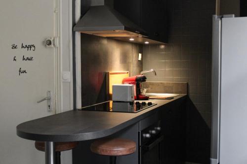 a kitchen with a black counter and a counter top at Le Duplex appartement proche de la Cathédrale in Bayeux
