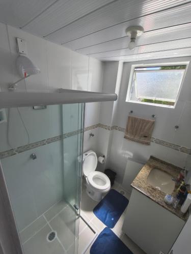 a bathroom with a shower and a toilet and a sink at Quarto em Apartamento na Trindade in Florianópolis