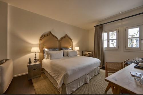 a bedroom with a large white bed and a table at Puro Grand Hotel in Palma de Mallorca