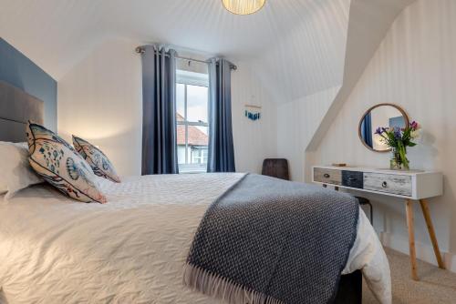 a bedroom with a bed and a mirror and a window at 2 Bed in Bude oc-u31759 in Bude