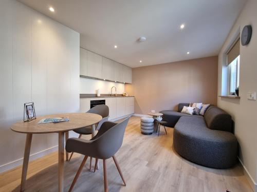 a kitchen and living room with a table and a couch at LÖYLY Egmond in Egmond aan Zee