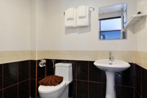 a bathroom with a toilet and a sink at THE BRETON Hotel in Ban O Pao