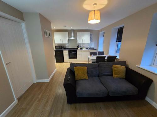 a living room with a couch and a kitchen at 4b Smart Apartments in Newark-on-Trent