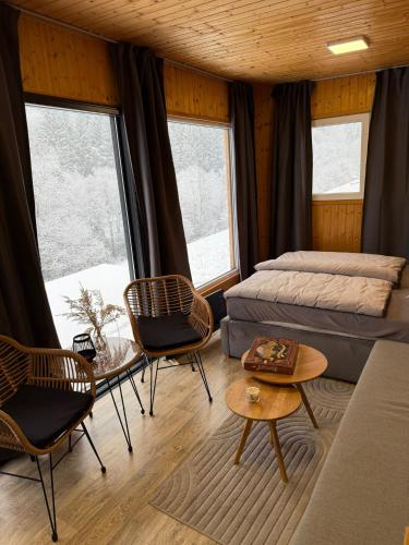 a bedroom with two beds and a table and chairs at Domček Lazy in Štôla
