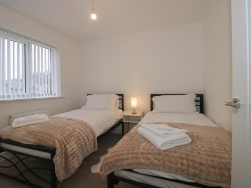 two twin beds in a room with a window at 10 The Colliery in Telford