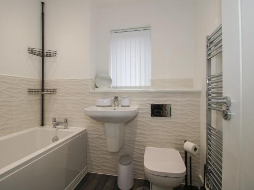 a bathroom with a sink and a toilet and a tub at 10 The Colliery in Telford