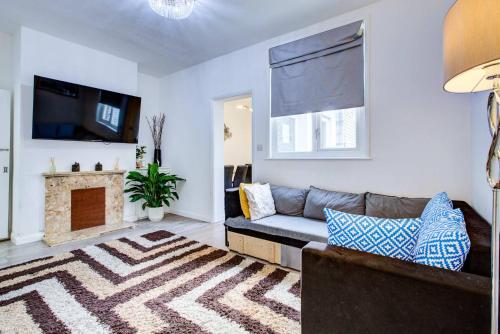 a living room with a couch and a fireplace at Newly Refurbished 3 Bed 2.5 Bath House in Staines in Staines