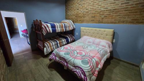 a small bedroom with a bed and a couch at Casa 12o - Paso de la Patria in Paso de la Patria
