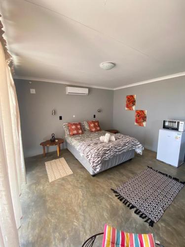a bedroom with a bed and a table in it at Petrified forest restcamp in Khorixas
