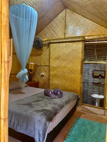 a bedroom with a bed with a blue curtain at Bunga Hut Koh Lanta in Ko Lanta