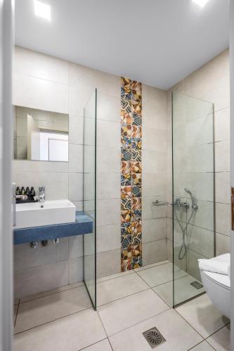 a bathroom with a glass shower and a sink at Amaryllis in Platanias