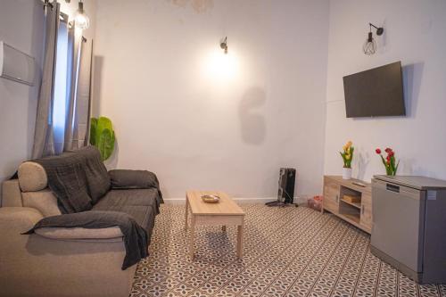 a living room with a couch and a tv at Ruralux Aroche in Aroche