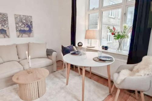 a living room with a table and a couch at Central 1BR Studio - Walk Everywhere in Aarhus in Aarhus