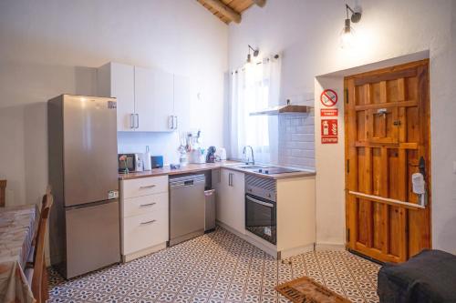 a small kitchen with a refrigerator and a sink at Ruralux Aroche in Aroche