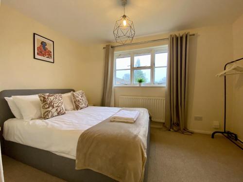 a bedroom with a bed and a window at Comfortable 2 Bedroom House in Bracknell in Bracknell