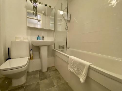 a white bathroom with a toilet and a sink at Comfortable 2 Bedroom House in Bracknell in Bracknell