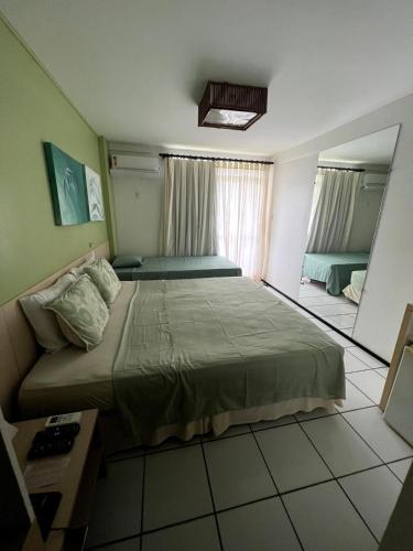 a small bedroom with a bed and a mirror at Hotel em Barreirinhas in Barreirinhas