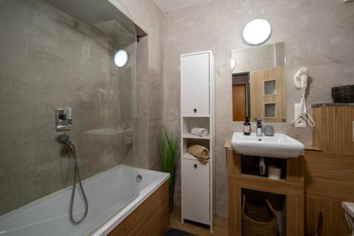 a bathroom with a tub and a sink and a shower at Apartmány Caffe & Grill in Roudnice nad Labem
