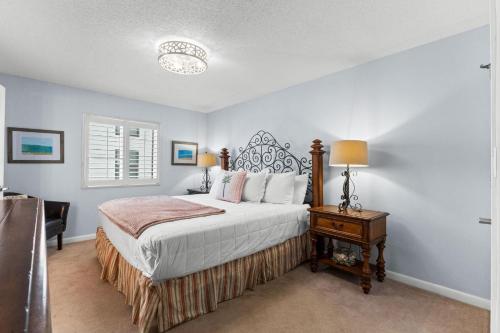 a bedroom with a bed and a table with a lamp at Dune Pointe 402 - Shells, Surf & Sea Turtles in Fort Walton Beach