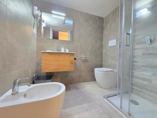 a bathroom with a sink and a toilet and a shower at Villetta Tina Private Pool - Torre Pali in Torre Pali