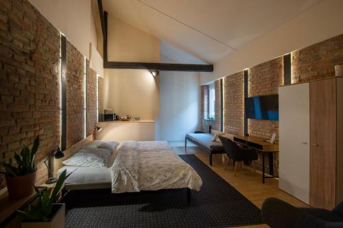 a bedroom with a bed and a brick wall at Apartmány Caffe & Grill in Roudnice nad Labem