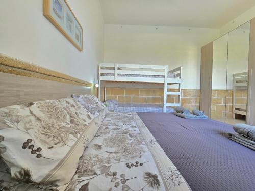 a bedroom with a bed and a bunk bed at Villetta Tina Private Pool - Torre Pali in Torre Pali