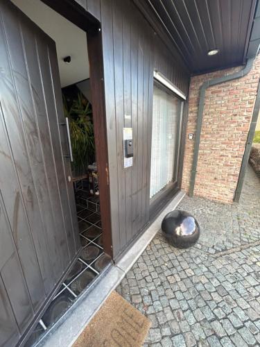 a door of a house with a cat laying next to it at Steves Place Haasdonk in Beveren