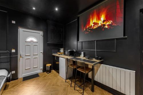 a kitchen with a fireplace on the wall at Le Spa Nocturne in Le Petit-Quevilly