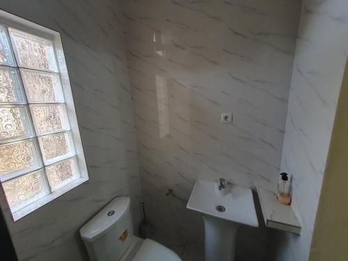 ein weißes Badezimmer mit Toilette und Waschbecken in der Unterkunft Casa Cacheu Homestay in Bissau