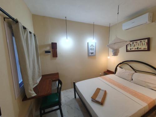 ein kleines Schlafzimmer mit einem Bett und einem Fenster in der Unterkunft Casa Cacheu Homestay in Bissau
