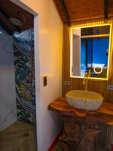 a bathroom with a stone sink and a mirror at La Finca De Frida in Guatapé
