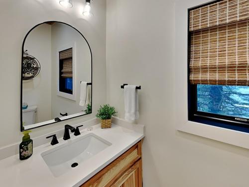 a bathroom with a sink and a mirror and a window at Bear on the Lake in Oakland