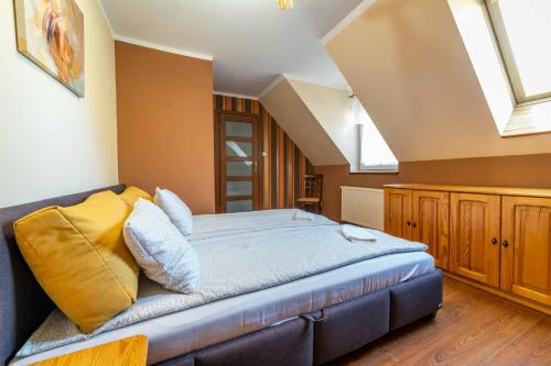 a bedroom with a large bed with yellow pillows at LAKE VIEW House in Mikołajki