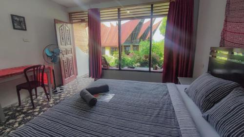 a bedroom with a bed with a phone and a window at Leokap Homestay in Tuktuk Siadong