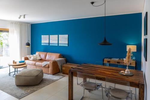 a blue living room with a couch and a table at maresoul - Ferienapartment mar in Raposeira