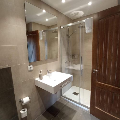 a bathroom with a sink and a shower at Hotel Casa de Indianos Don Tomás in Nueva de Llanes