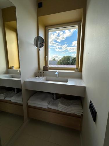 a bathroom with a sink and a window and towels at CASA ioio in Jaunay-Clan