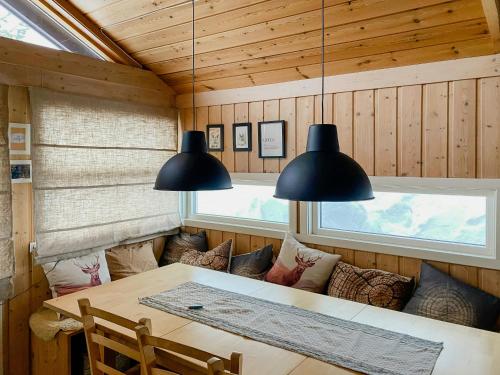a dining room with a table and a couch at Mountain Cabin With Glacier Views in Norheimsund