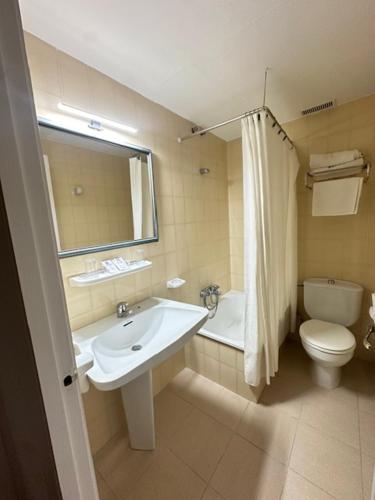 a bathroom with a sink and a toilet and a mirror at Hotel Castillo de Montemayor in Montemayor