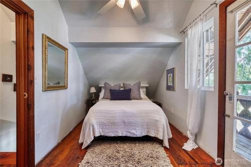 a bedroom with a bed with a white bedspread at Charming and cozy cottage at Maple Beach in Point Roberts
