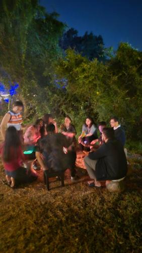 a group of people sitting around a camp fire at Zomad Hostels Pondicherry, Auroville Road in Auroville