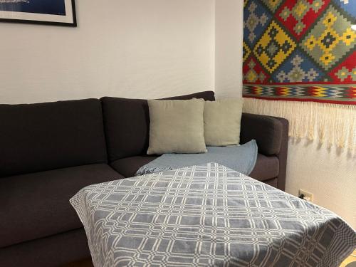 a couch and a bed in a living room at Sentralt og koselig in Kristiansand
