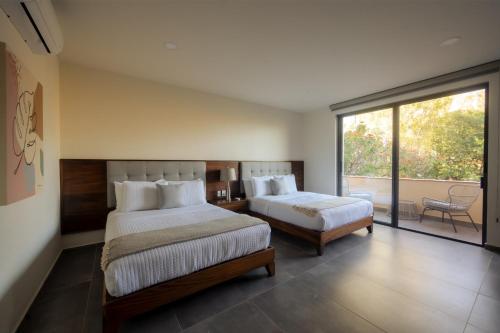 a bedroom with two beds and a large window at Quinta San Carlos in San Pedro Tesistán
