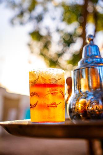 a drink on a plate next to a glass at Traditional Berber Eco Farm Stay in Agadir