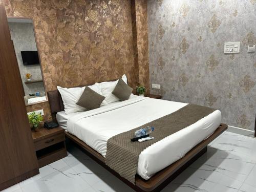 a bedroom with a large bed and a mirror at Hotel Apex Inn Hyderabad Airport in Hyderabad